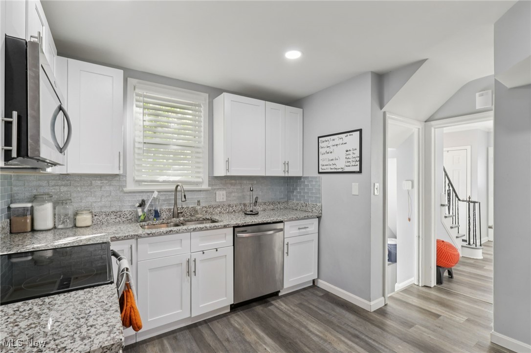 1503 Oakmount Road South Euclid, OH 44121 - Photo 19 of 50 Kitchen featuring light stone countertops, stainless steel appliances, white cabinetry, dark wood finished floors, and recessed lighting