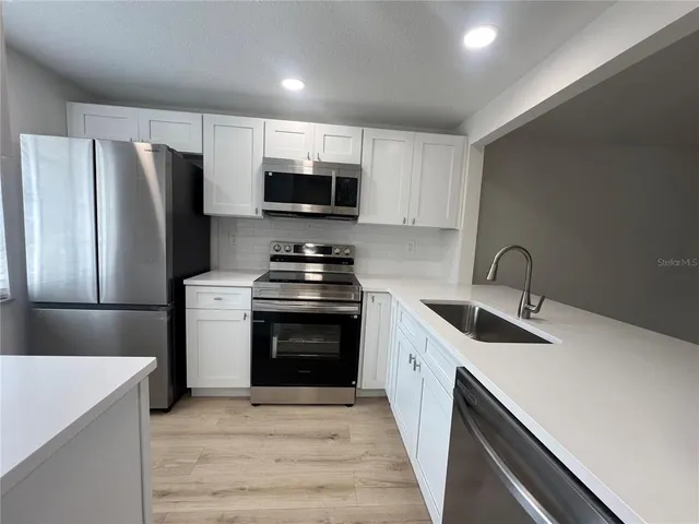 a kitchen with stainless steel appliances a refrigerator stove and microwave