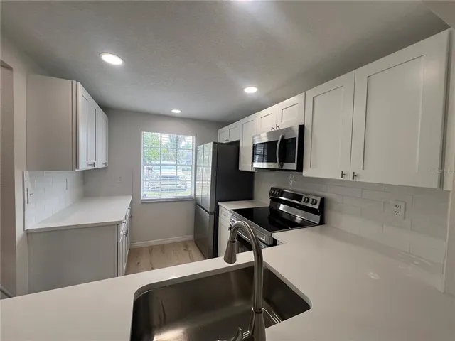 a kitchen with a refrigerator a stove a microwave and cabinets