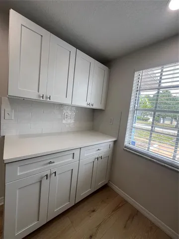 a kitchen with granite countertop white cabinets and a window