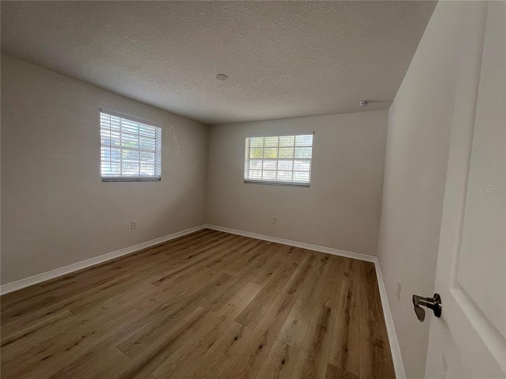 4223 Sheldon Place, Unit 23 New Port Richey, FL 34652 - Photo 7 of 13 a view of an empty room with wooden floor and a window