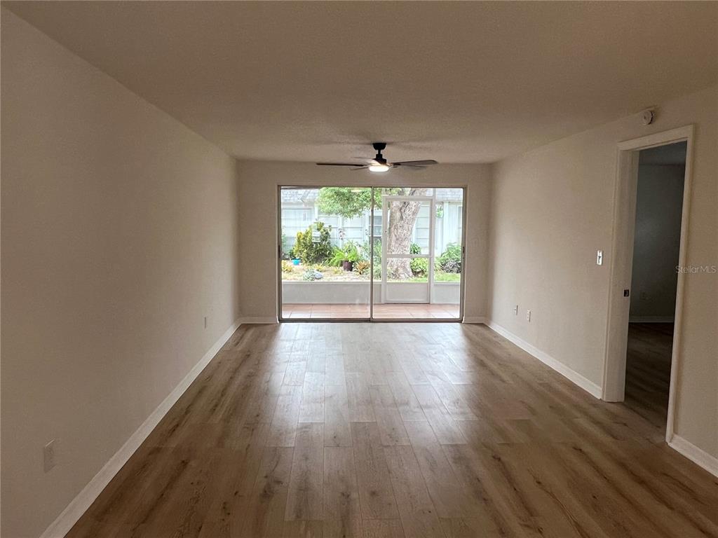 4223 Sheldon Place, Unit 23 New Port Richey, FL 34652 - Photo 8 of 13 an empty room with wooden floor and windows