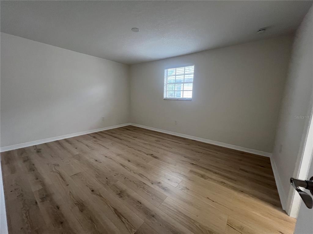 4223 Sheldon Place, Unit 23 New Port Richey, FL 34652 - Photo 9 of 13 a view of an empty room with wooden floor and a window