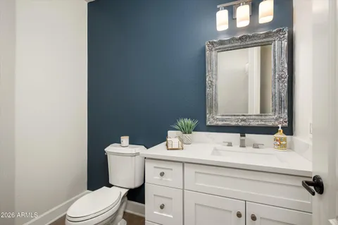 a bathroom with a sink vanity mirror and toilet