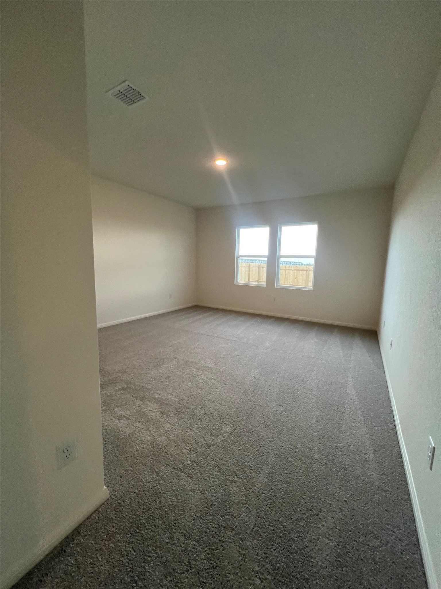 124 Rother Place Taylor, TX 76574 - Photo 10 of 12 A spacious room offers ample natural light and plush carpeting, perfect for a cozy retreat.