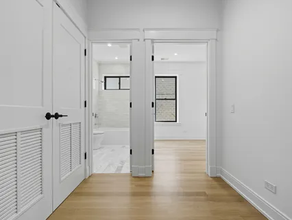 a view of a hallway with wooden floor and staircase