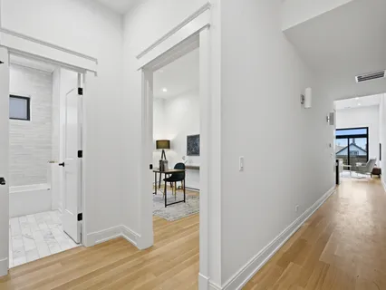a view of a hallway view with wooden floor and dining room