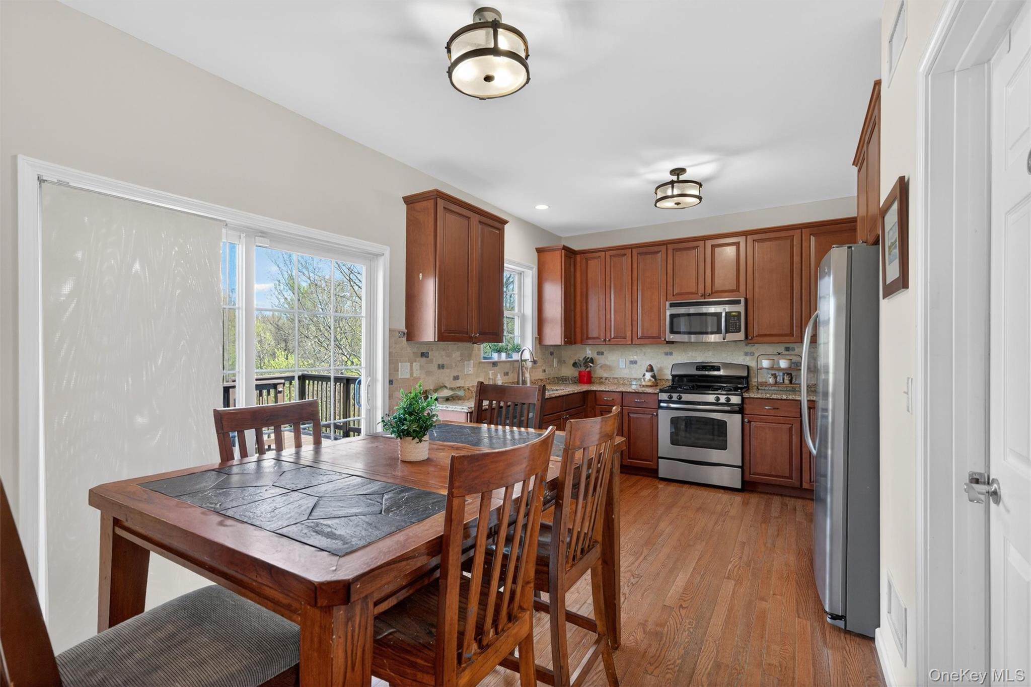 2 Primrose Lane Chester, NY 10918 - Photo 17 of 42 a kitchen with stainless steel appliances a dining table chairs stove refrigerator and microwave