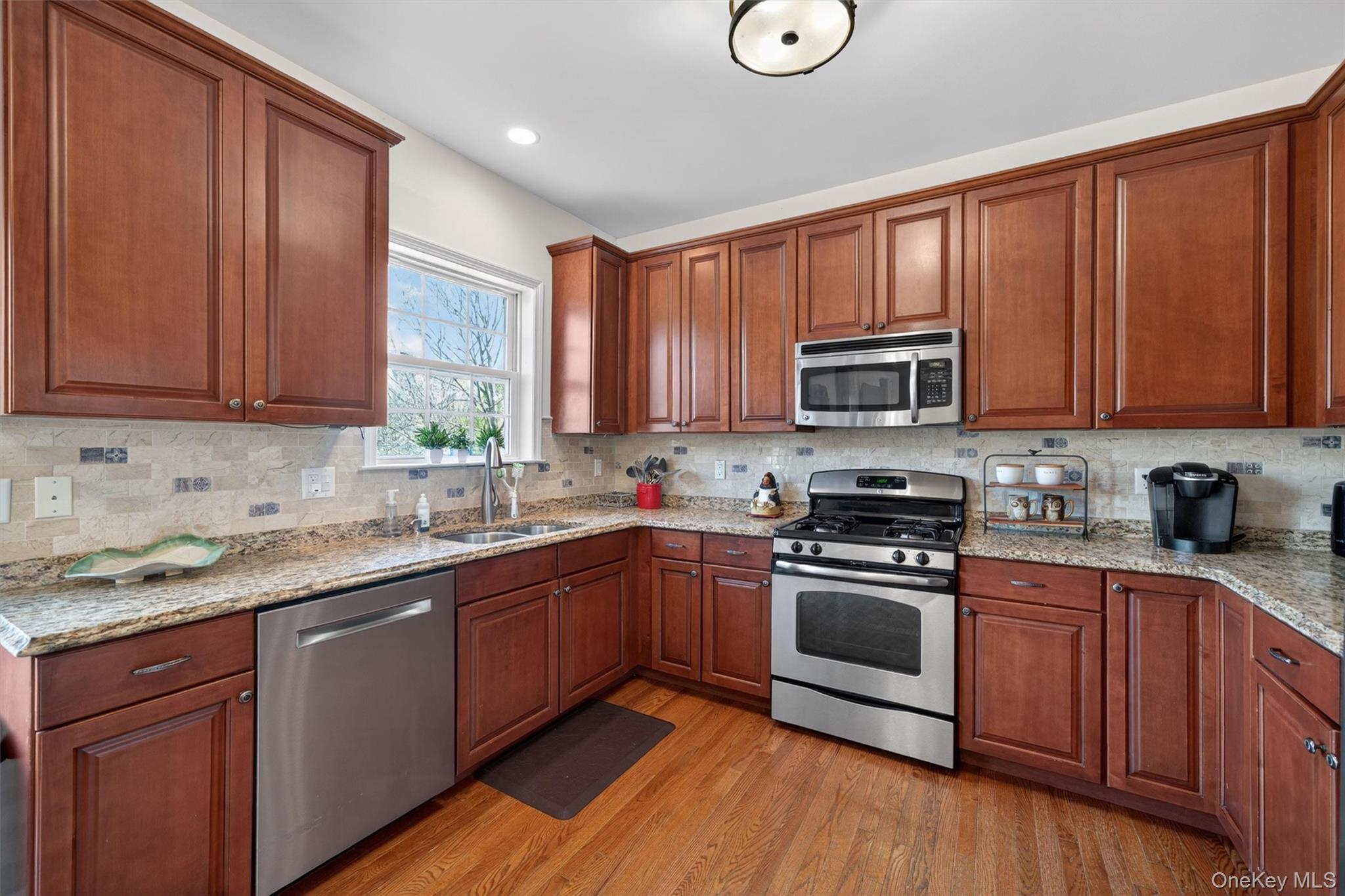 2 Primrose Lane Chester, NY 10918 - Photo 18 of 42 a kitchen with stainless steel appliances granite countertop wooden cabinets a sink and dishwasher a stove top oven with wooden floor