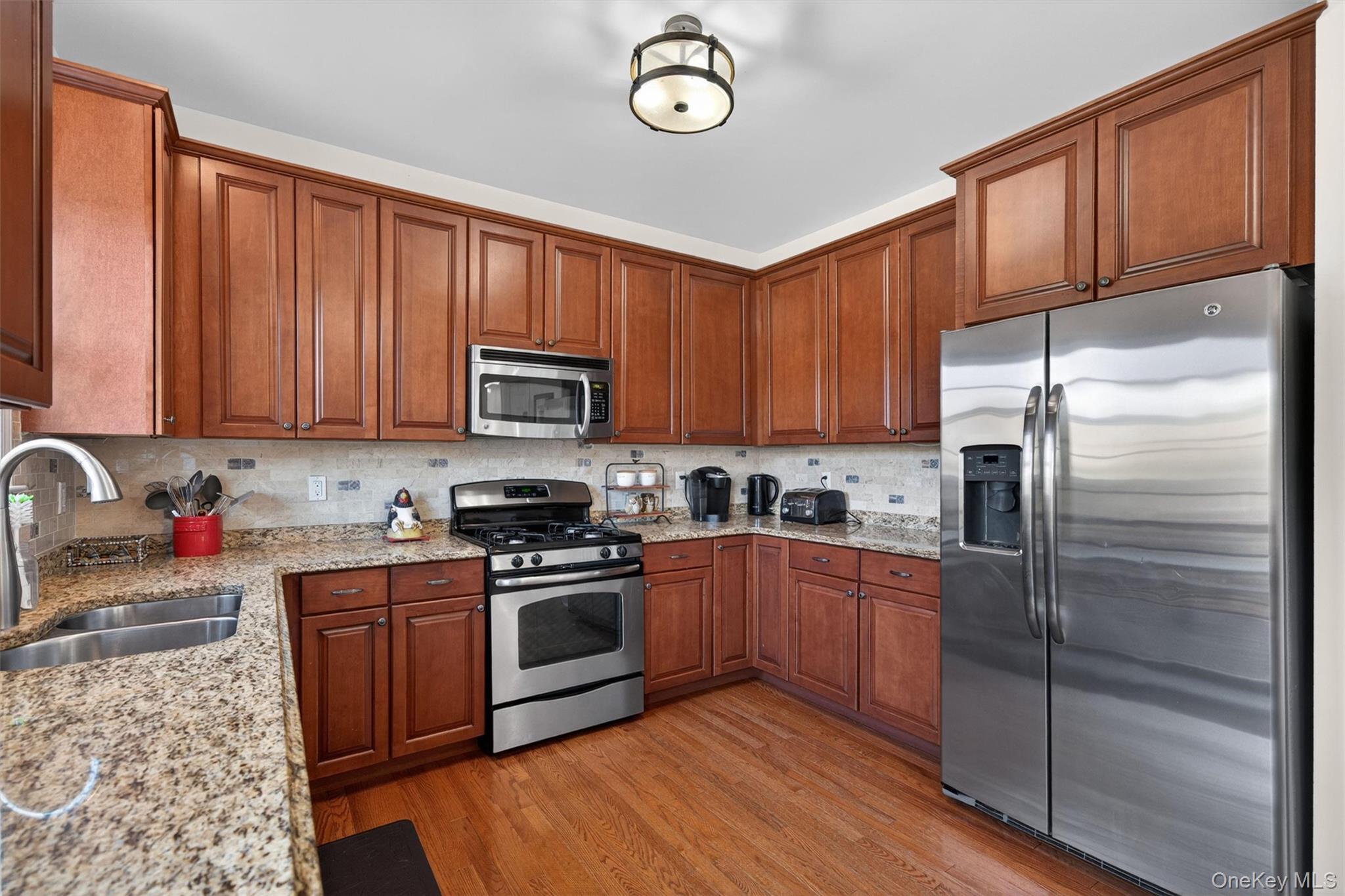 2 Primrose Lane Chester, NY 10918 - Photo 19 of 42 a kitchen with stainless steel appliances granite countertop a stove top oven a refrigerator and dishwasher with wooden cabinets