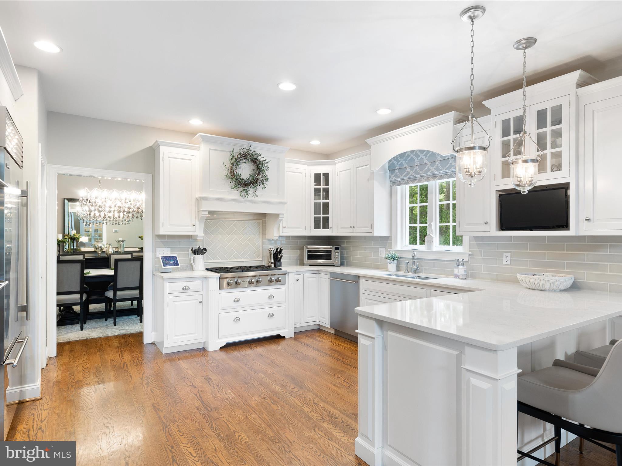 130 Waterfall Lane Landenberg, PA 19350 - Photo 11 of 49 a kitchen with stainless steel appliances granite countertop a sink a stove a refrigerator and a dining table with wooden floor