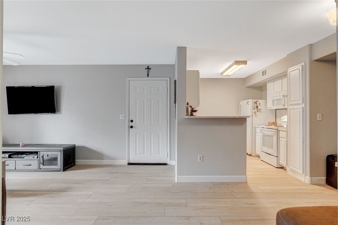 555 East Silverado Ranch Boulevard, Unit 1172 Las Vegas, NV 89183 - Photo 14 of 29 Unfurnished living room featuring baseboards and light wood-style floors
