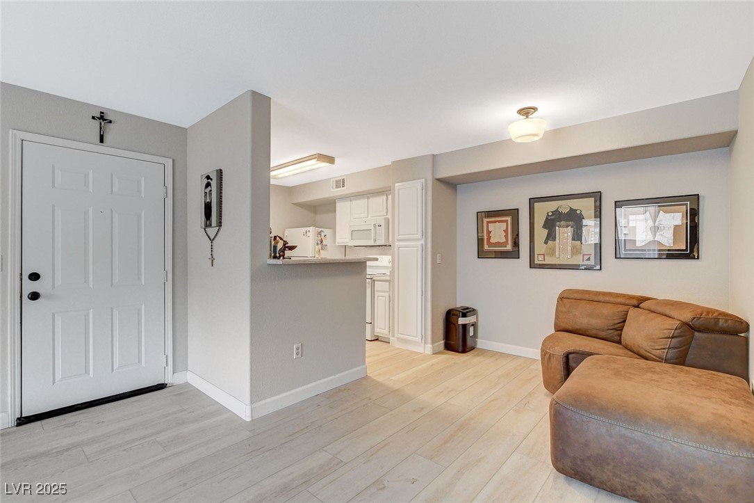 555 East Silverado Ranch Boulevard, Unit 1172 Las Vegas, NV 89183 - Photo 15 of 29 Living area featuring light wood-type flooring and baseboards