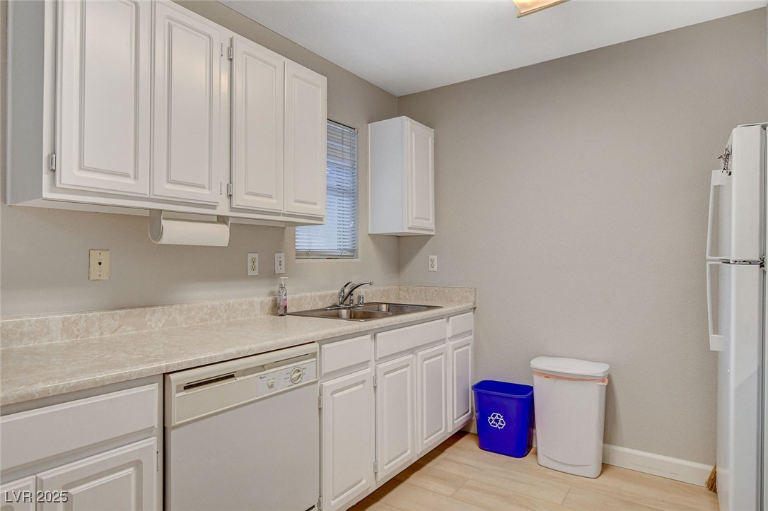 555 East Silverado Ranch Boulevard, Unit 1172 Las Vegas, NV 89183 - Photo 18 of 29 Kitchen featuring white appliances, light countertops, white cabinetry, and light wood-style flooring