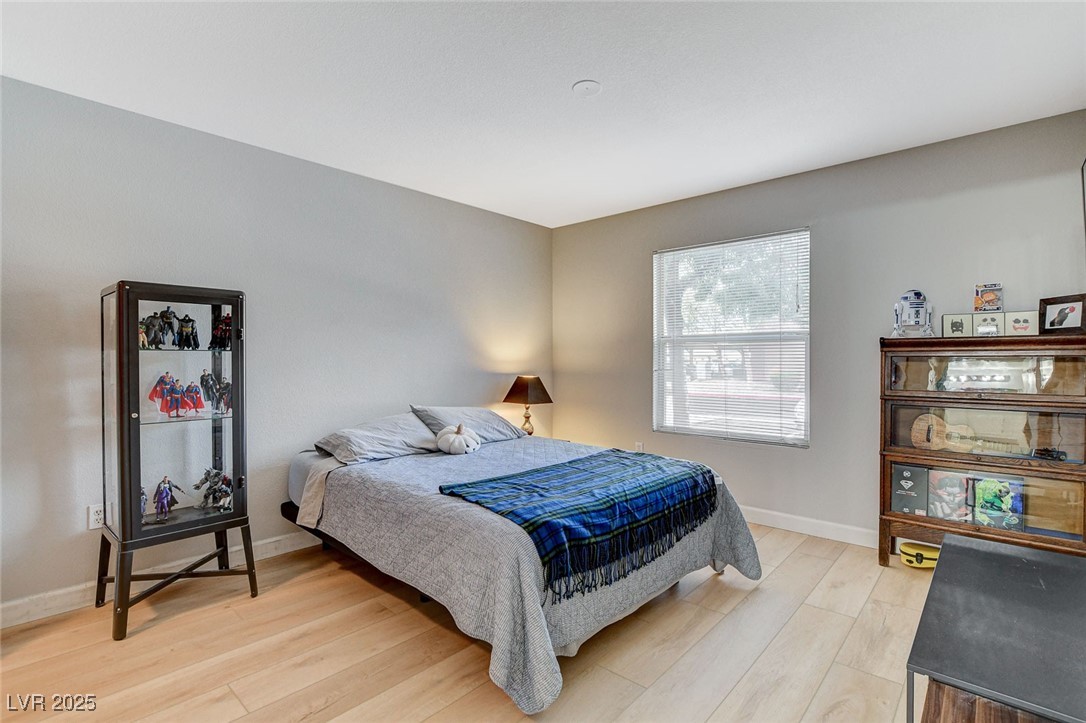 555 East Silverado Ranch Boulevard, Unit 1172 Las Vegas, NV 89183 - Photo 21 of 29 Bedroom featuring light wood-style floors and baseboards