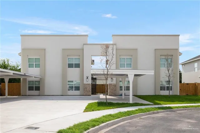 a white house with a yard and plants