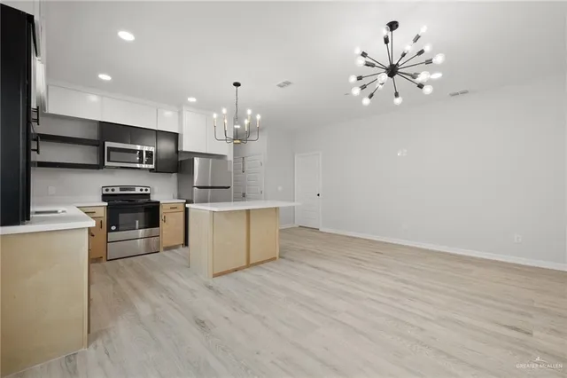 a large kitchen with kitchen island a sink stainless steel appliances and cabinets