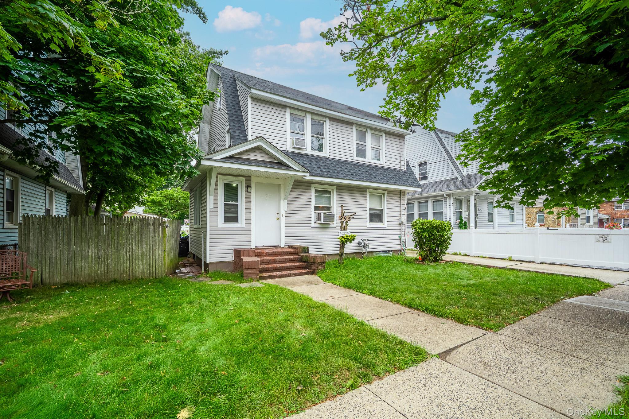 295 Washington Street Hempstead, NY 11550 - Photo 1 of 17 a front view of a house with a yard and porch