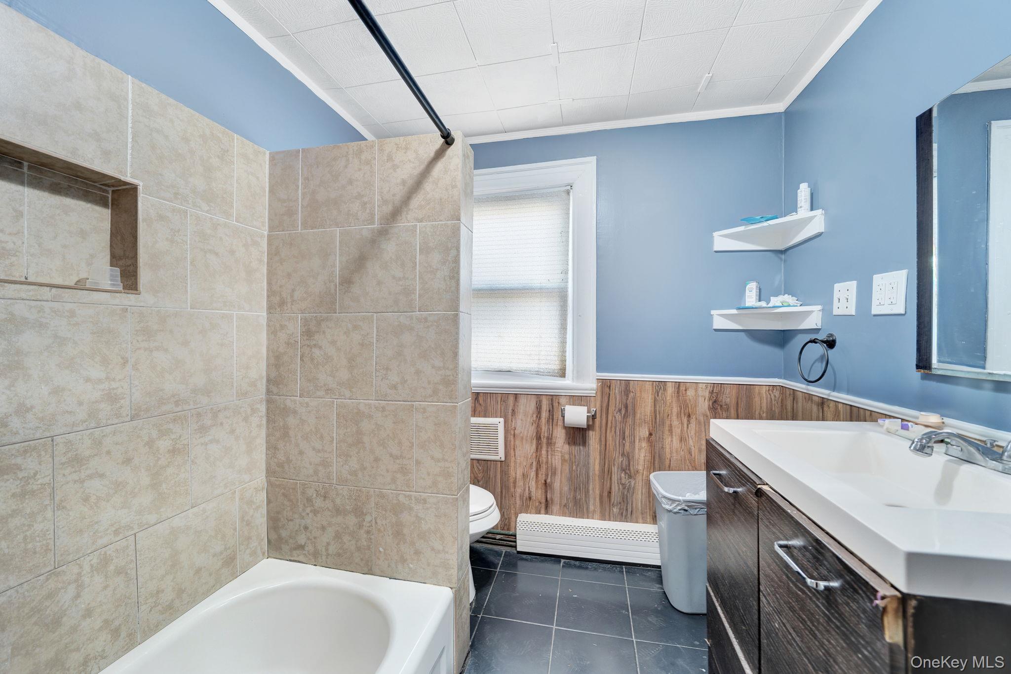 295 Washington Street Hempstead, NY 11550 - Photo 11 of 17 a bathroom with a sink a toilet and bathtub