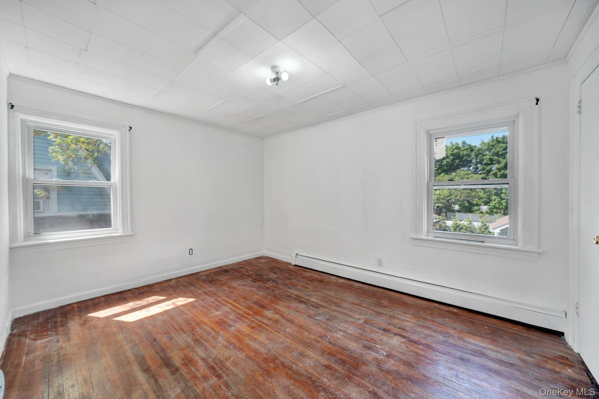 295 Washington Street Hempstead, NY 11550 - Photo 12 of 17 an empty room with wooden floor and windows