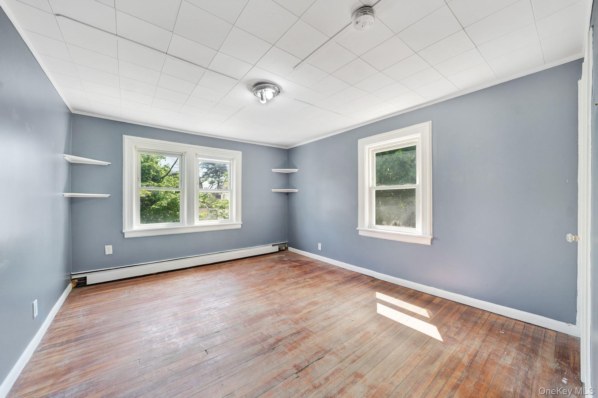 295 Washington Street Hempstead, NY 11550 - Photo 13 of 17 an empty room with wooden floor and windows