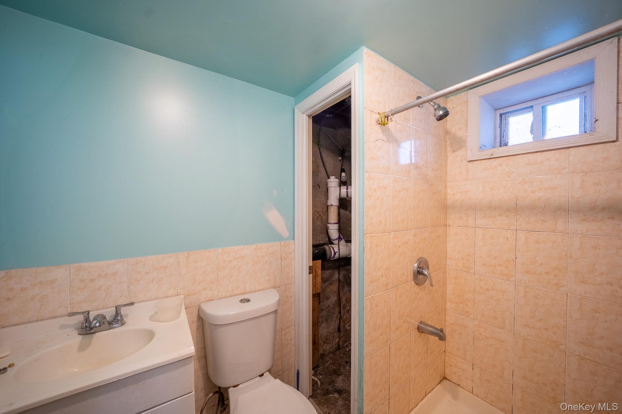 295 Washington Street Hempstead, NY 11550 - Photo 15 of 17 a bathroom with a toilet a sink and shower