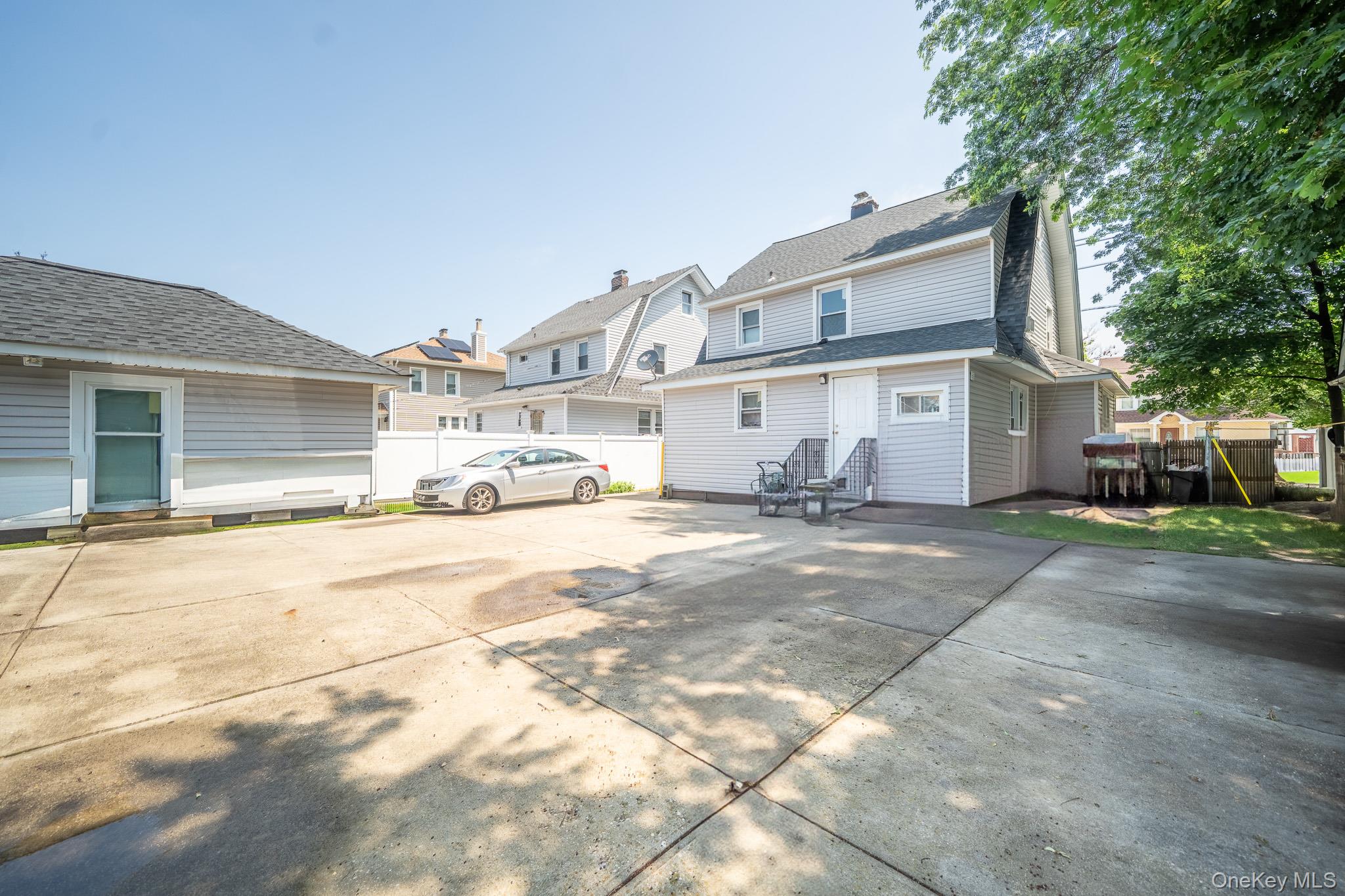 295 Washington Street Hempstead, NY 11550 - Photo 16 of 17 a front view of a house with a yard and a garage