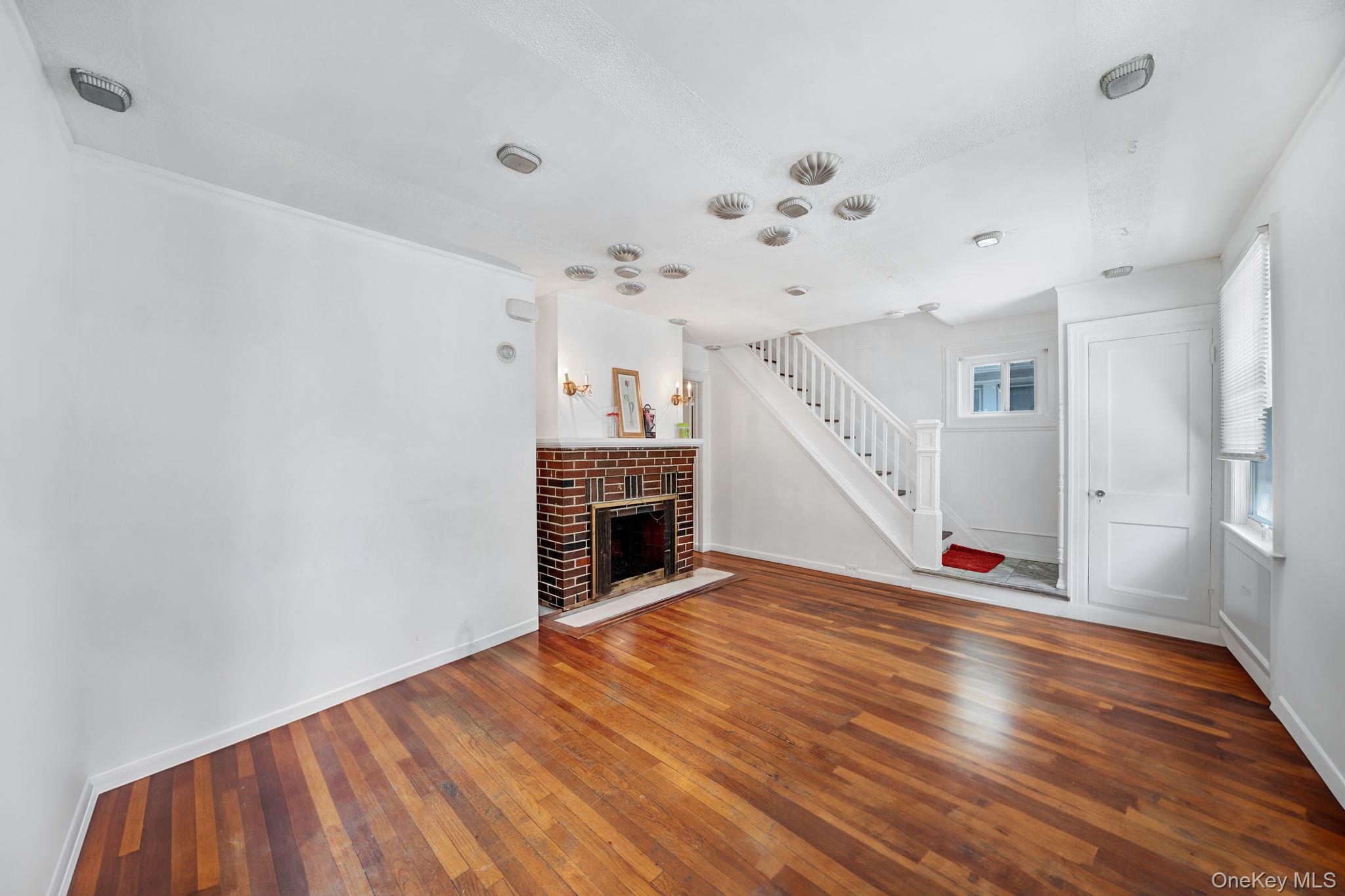 295 Washington Street Hempstead, NY 11550 - Photo 2 of 17 a view of empty room with wooden floor and fan