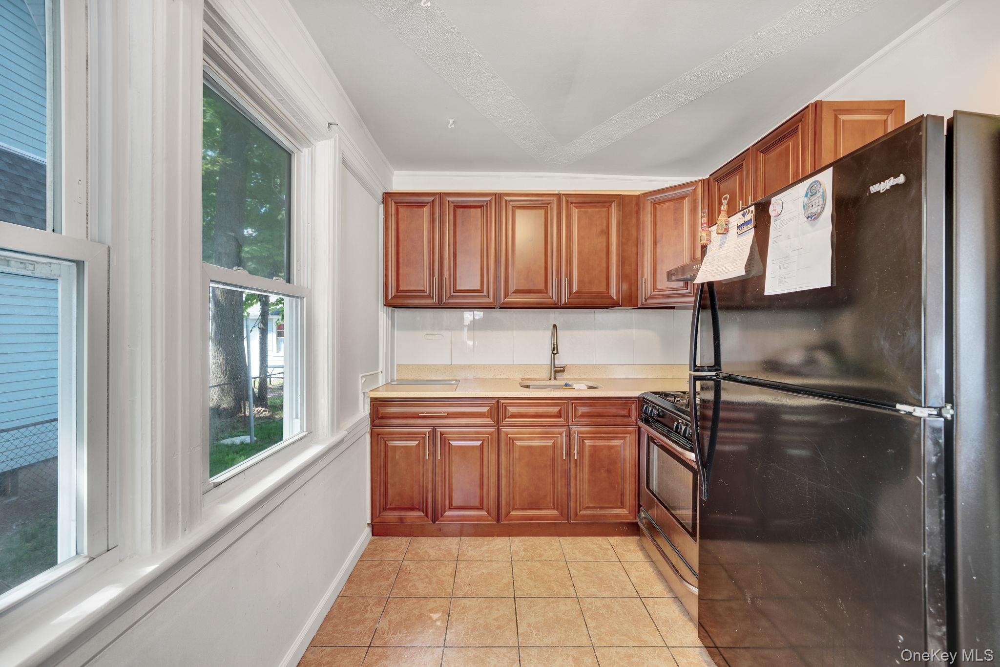 295 Washington Street Hempstead, NY 11550 - Photo 4 of 17 a kitchen with stainless steel appliances granite countertop a refrigerator and a sink