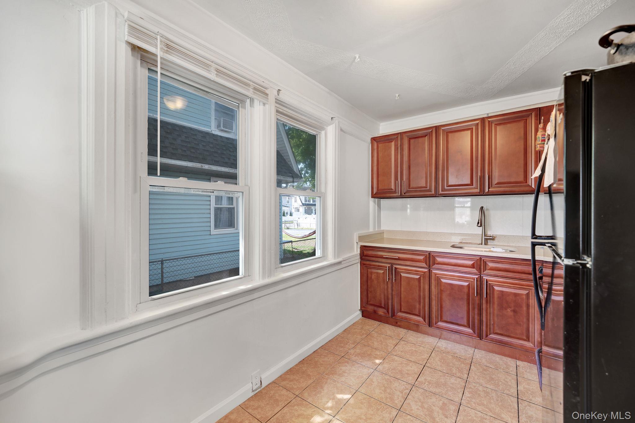 295 Washington Street Hempstead, NY 11550 - Photo 5 of 17 a kitchen with stainless steel appliances granite countertop a refrigerator and a sink