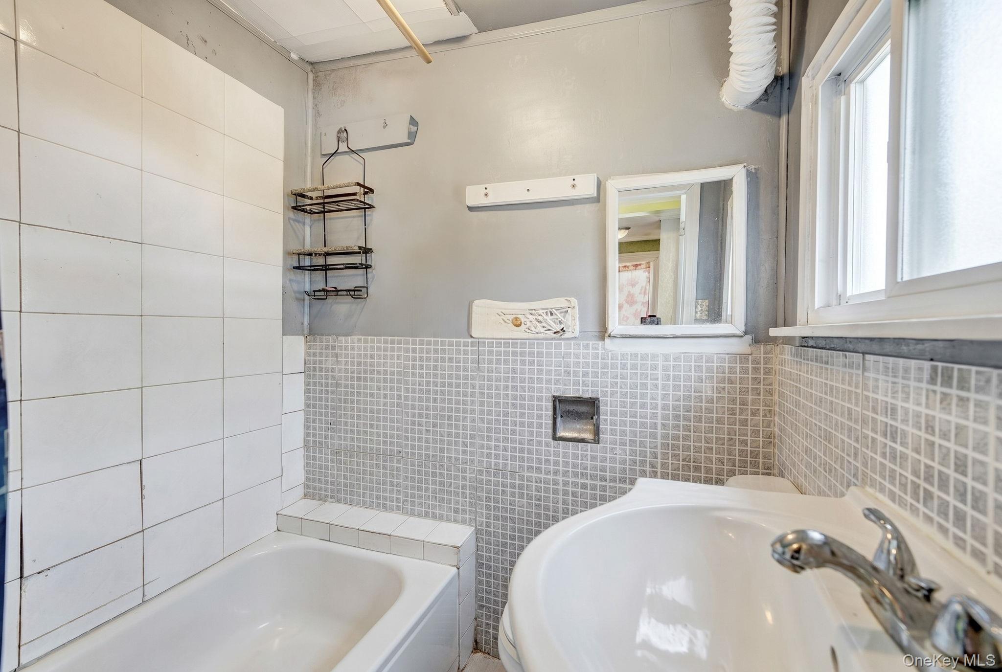 295 Washington Street Hempstead, NY 11550 - Photo 8 of 17 a bathroom with a tub sink and shower