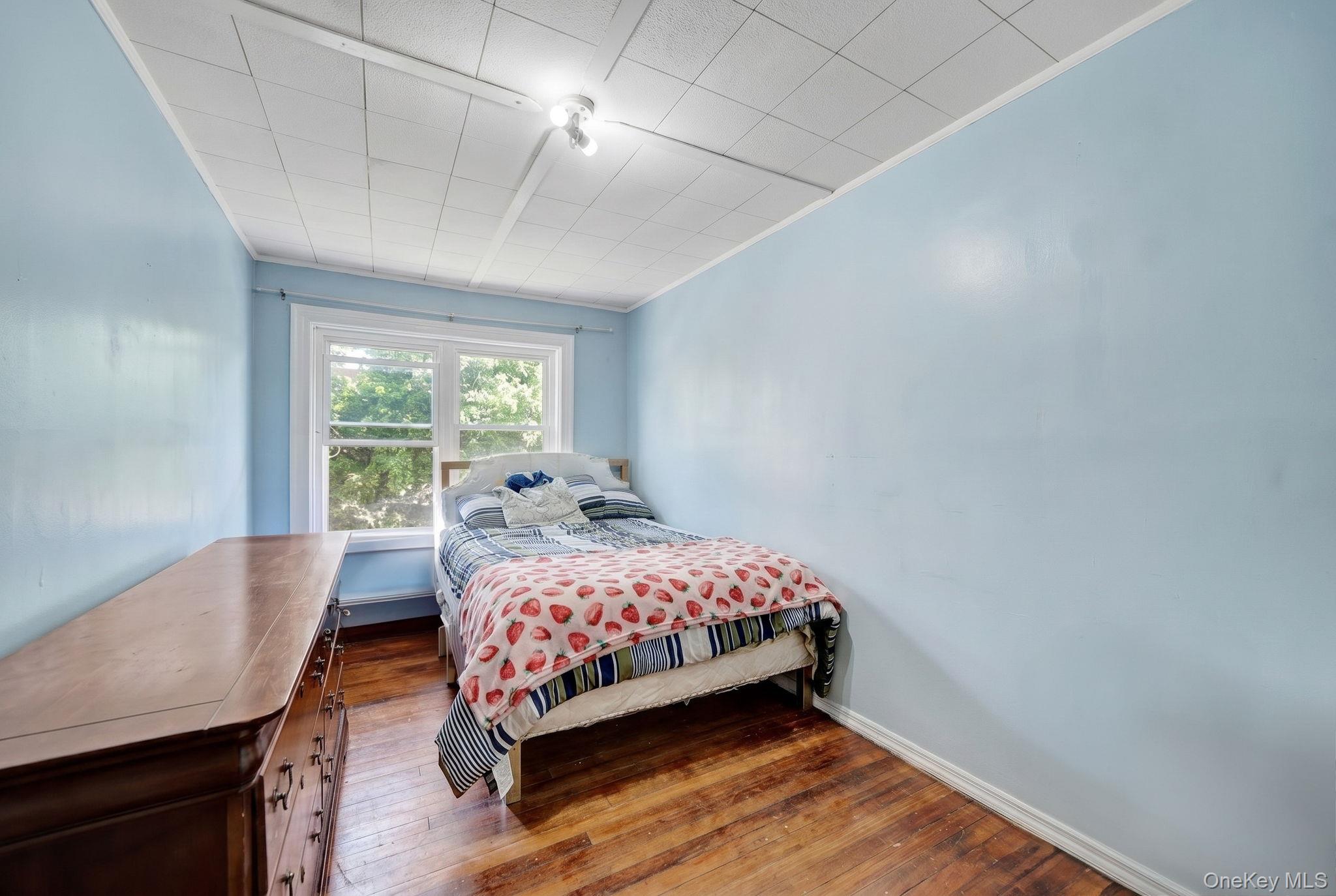 295 Washington Street Hempstead, NY 11550 - Photo 10 of 17 a bedroom with a bed and wooden floor