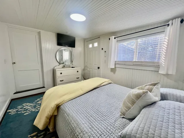 a bedroom with a bed and large windows
