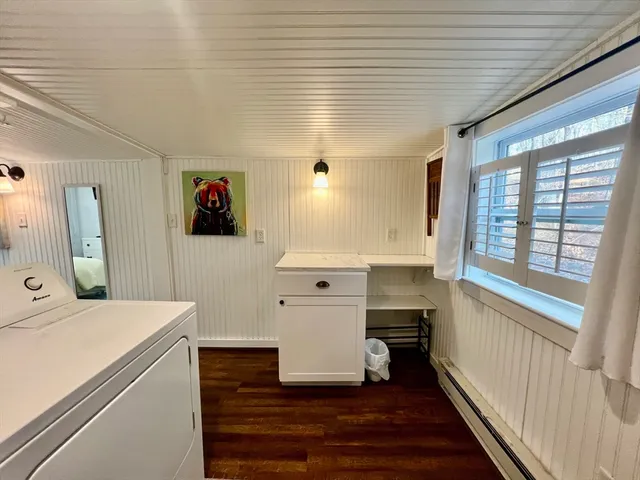 a view of a hallway with a white furniture a window and wooden floor