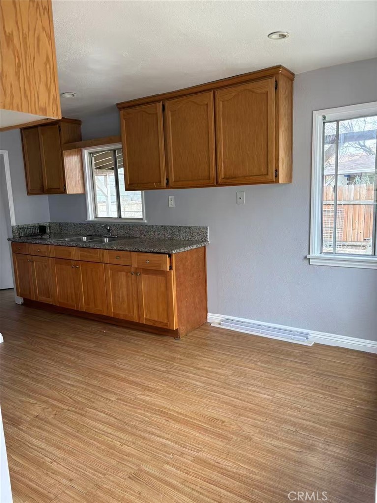 739 East Olive Street, Unit A Colton, CA 92324 - Photo 4 of 6 a kitchen with granite countertop wooden cabinets a sink and dishwasher
