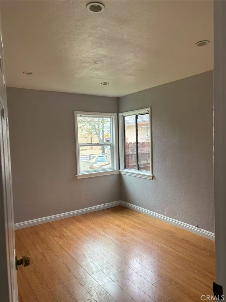 739 East Olive Street, Unit A Colton, CA 92324 - Photo 5 of 6 an empty room with wooden floor and windows