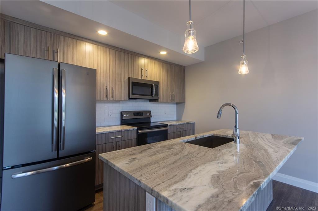 a kitchen with kitchen island a counter top space appliances and cabinets