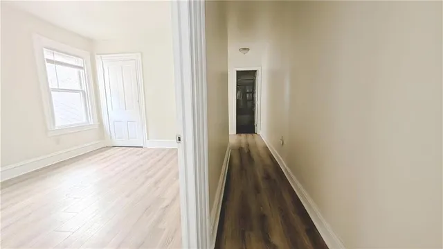 a view of a hallway with wooden floor and staircase
