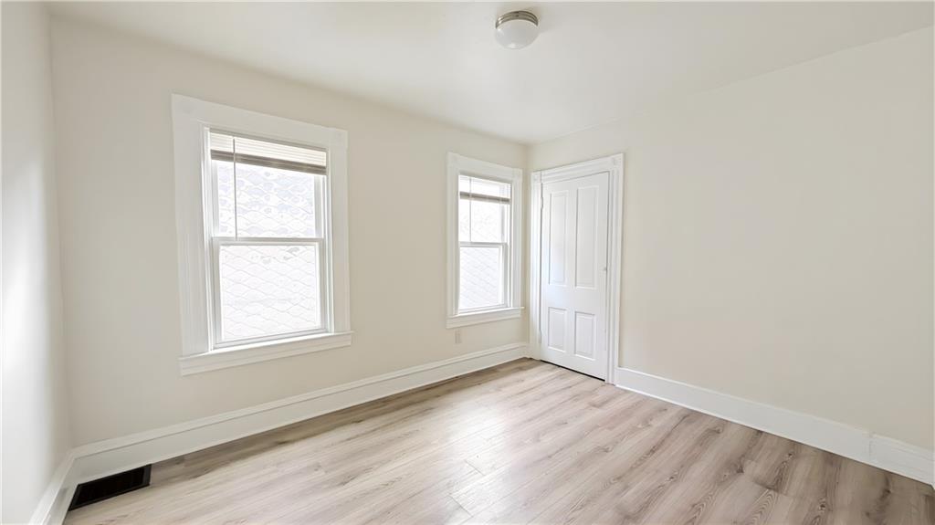735 Boquet Street McKees Rocks, PA 15136 - Photo 17 of 30 an empty room with wooden floor and windows