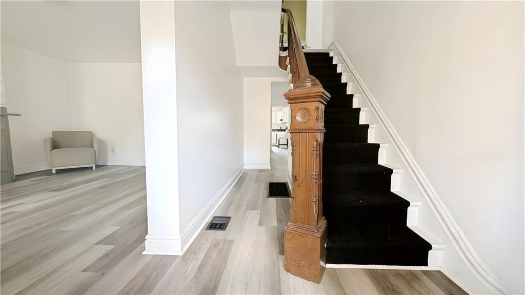 735 Boquet Street McKees Rocks, PA 15136 - Photo 3 of 30 a view of a staircase and white walls with wooden floor