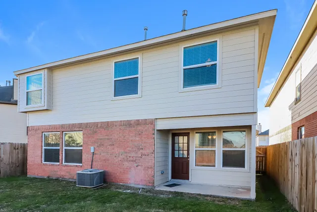 a view of brick house with a yard