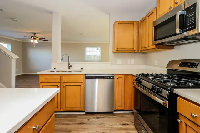 a kitchen with stainless steel appliances granite countertop a stove a sink and a microwave