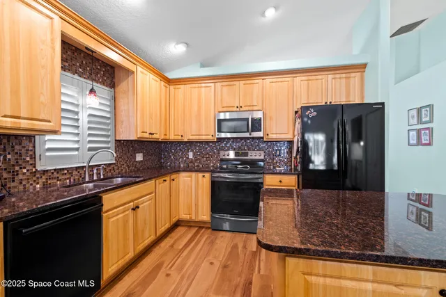 a kitchen with stainless steel appliances granite countertop a stove a sink dishwasher a refrigerator and a microwave oven