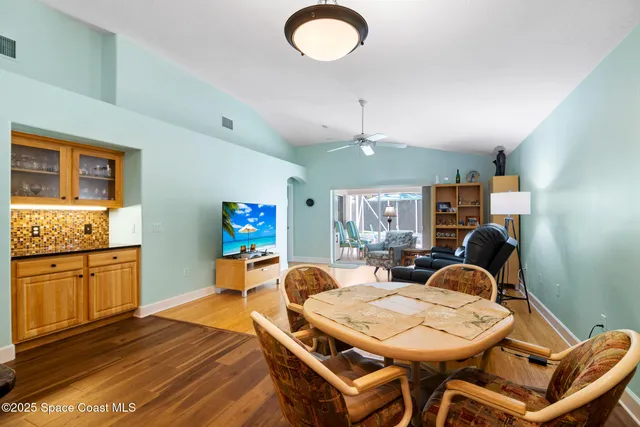 a living room with furniture a dining table and chairs with wooden floor