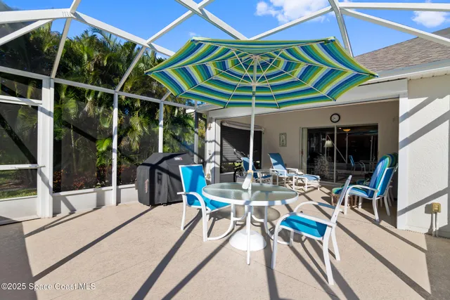 a view of a patio with table and chairs under an umbrella