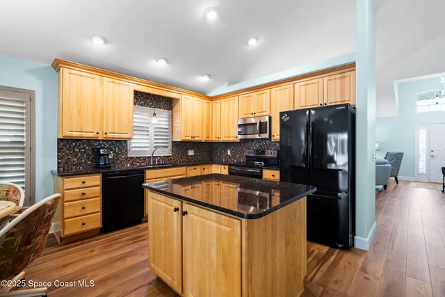a kitchen with granite countertop a refrigerator stove and sink