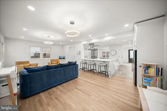 a living room with furniture and a dining table with wooden floor