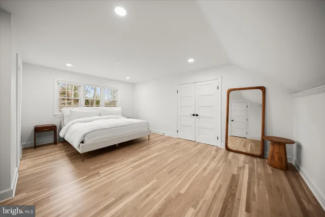 a bedroom with a bed and a wooden floor