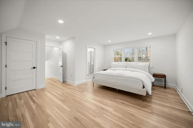 a bedroom with a bed and a wooden floor