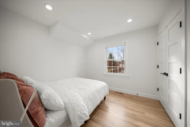 a bedroom with a bed and wooden floor